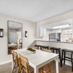 Dining area with table and bar height seating looking into the kitchen